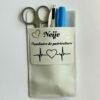 Pochette de blouse blanche personnalisée avec le prénom « Neige » et l’inscription « Auxiliaire de puériculture », contenant des ciseaux, un stylo et un marqueur bleu.
