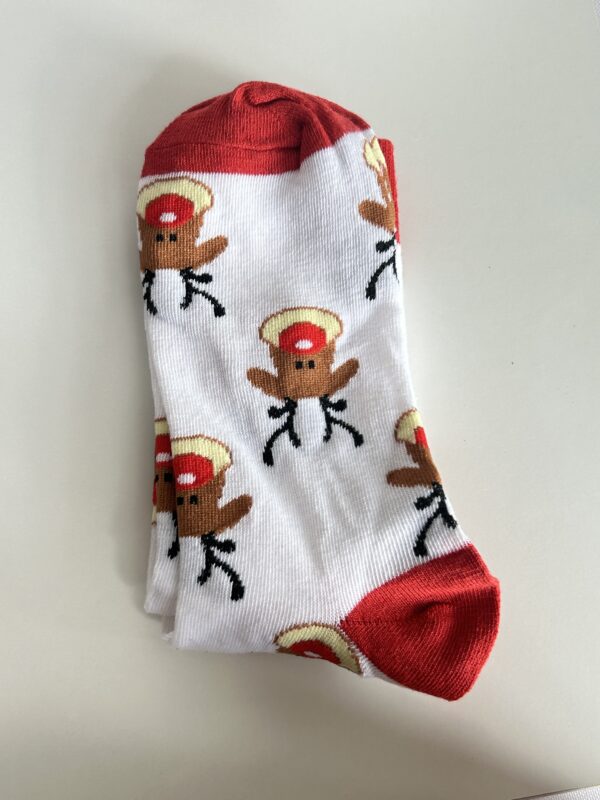 chaussettes-noel-renne-auxiliaire-de-puericulture Chaussettes de Noël blanches avec motifs rennes et détails rouges, accessoire festif inclus dans la Box de Noël auxiliaire de puériculture.